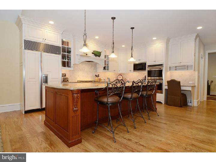 145 Sugartown Road Devon, PA 19333 - Photo 8 of 25 a kitchen with stainless steel appliances kitchen island granite countertop a table chairs and a refrigerator