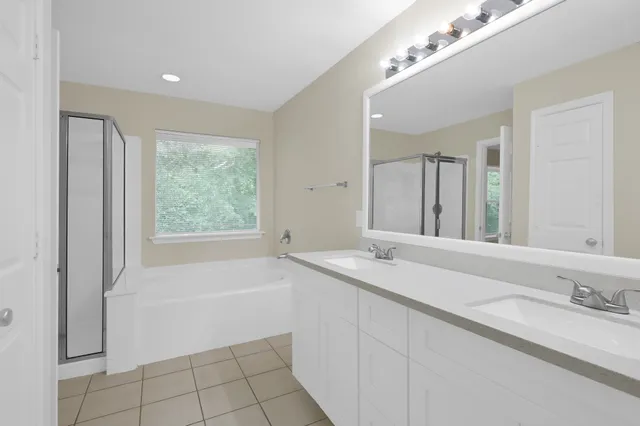 a bathroom with a granite countertop sink a mirror and a bathtub