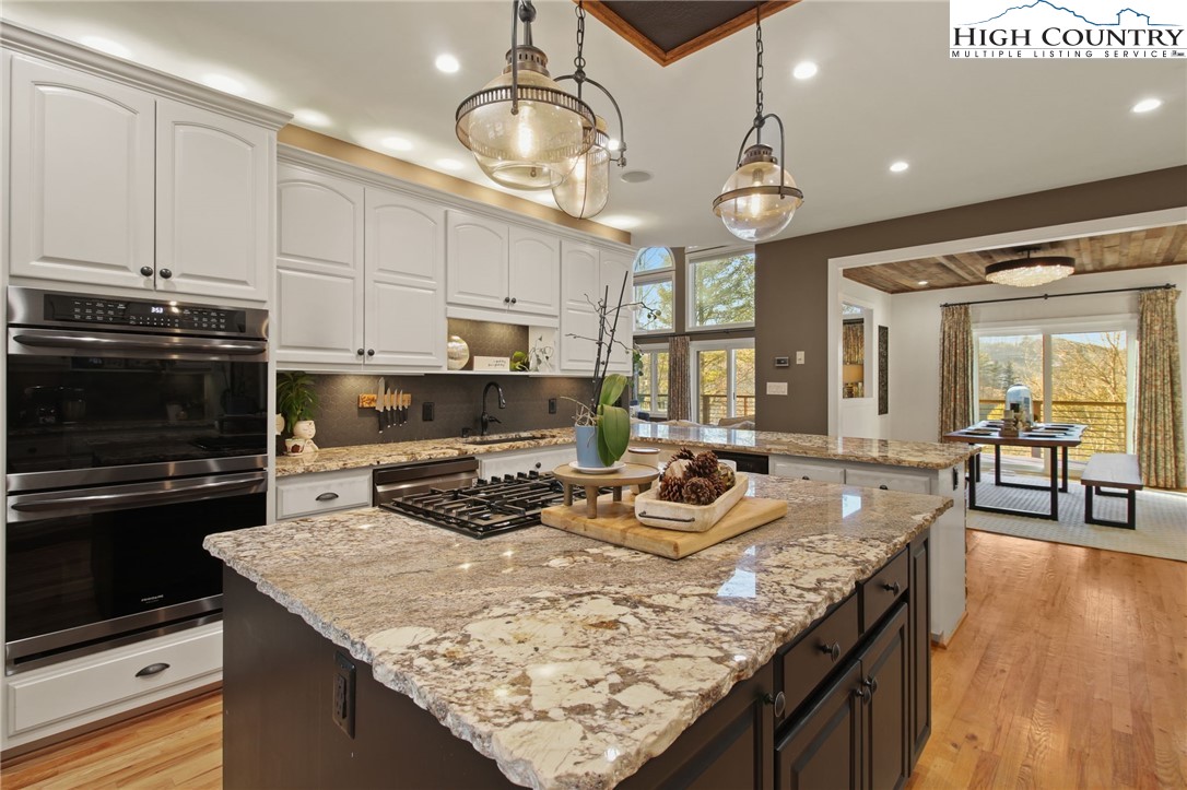 140 Gentry Road Boone, NC 28607 - Photo 24 of 49 a kitchen with granite countertop kitchen island stainless steel appliances a stove sink microwave and cabinets