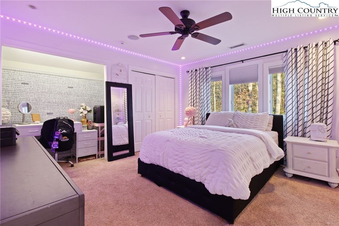 140 Gentry Road Boone, NC 28607 - Photo 38 of 49 a spacious bedroom with a bed and a chandelier