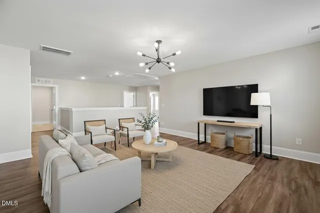 a large white kitchen with granite countertop a stove a sink a window and white cabinets