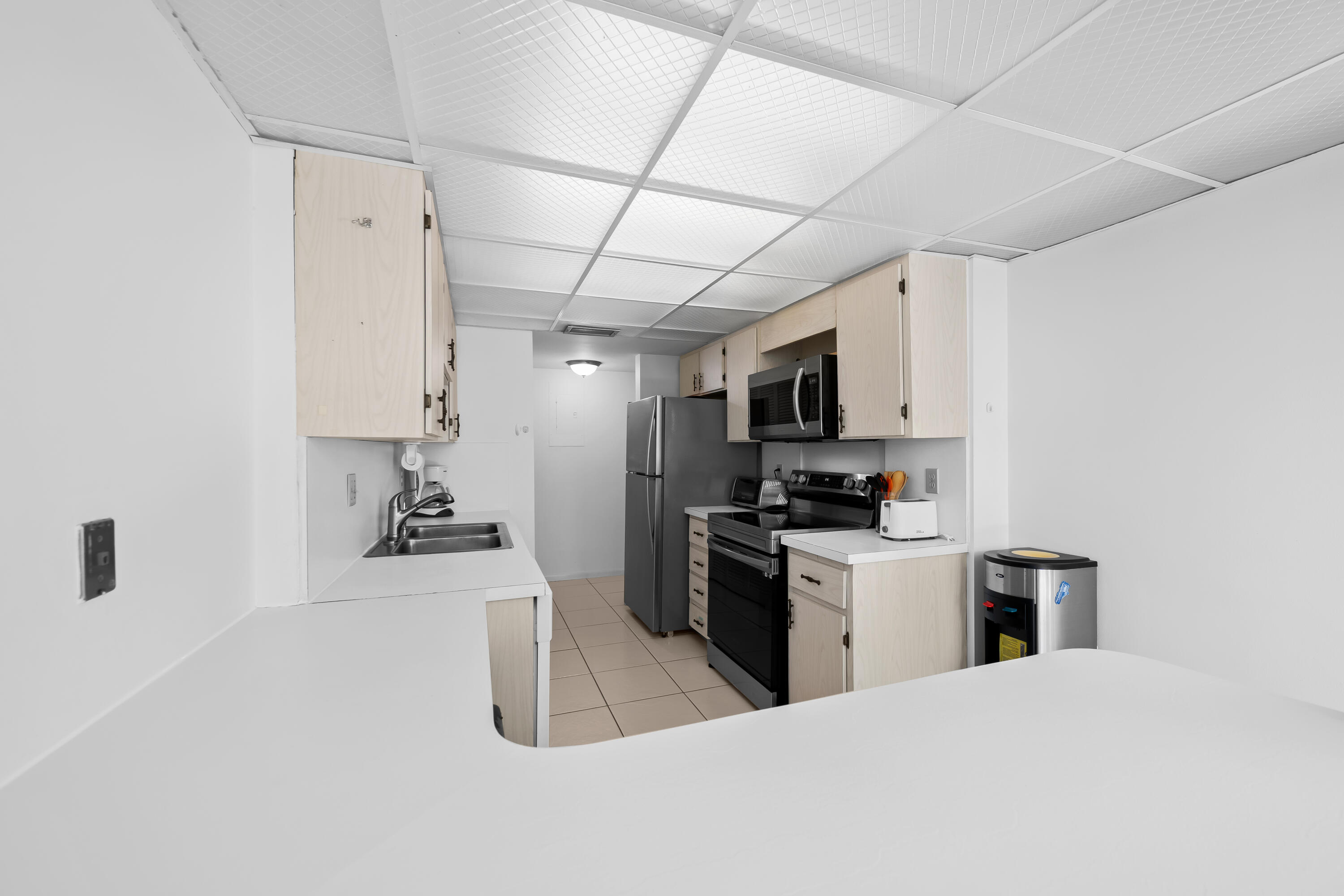 799 Jeffery Street, Unit 411 Boca Raton, FL 33487 - Photo 5 of 37 a kitchen with stainless steel appliances kitchen island granite countertop a refrigerator oven a sink dishwasher and white cabinets with wooden floor