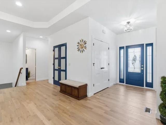 a spacious bedroom with a large bed and a chandelier