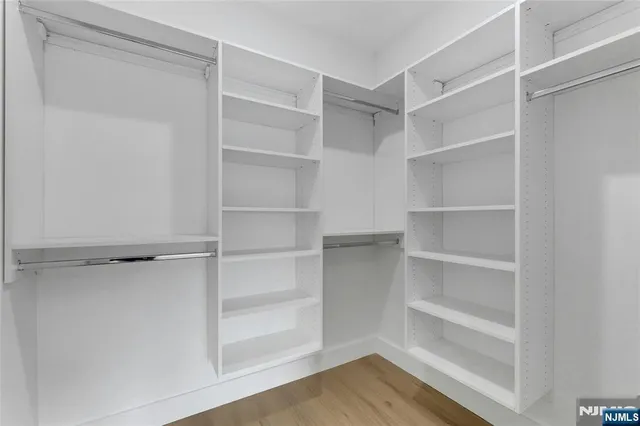 a view of walk in closet with empty racks
