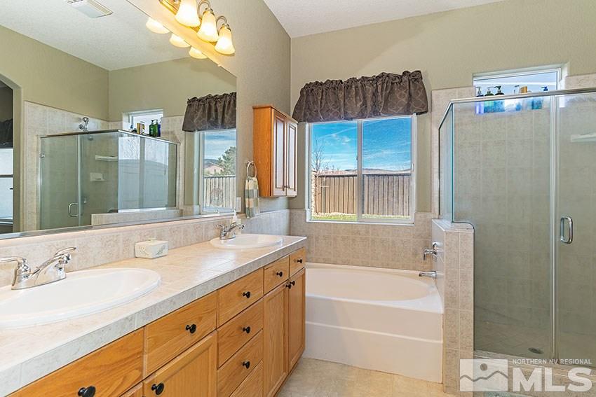 10220 Donnay Court Reno, NV 89521 - Photo 11 of 19 a bathroom with a granite countertop sink mirror and a bathtub