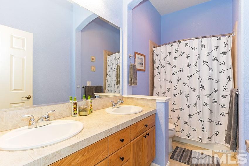 10220 Donnay Court Reno, NV 89521 - Photo 14 of 19 a bathroom with a granite countertop sink and a mirror
