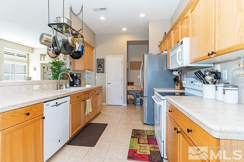 10220 Donnay Court Reno, NV 89521 - Photo 8 of 19 a kitchen with stainless steel appliances granite countertop a sink a stove and a refrigerator