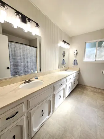 a spacious bathroom with double sink and a mirror