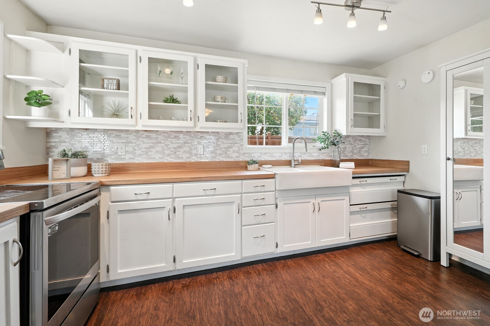 805 36th Street Anacortes, WA 98221 - Photo 7 of 39 a kitchen with stainless steel appliances granite countertop a sink a stove and wooden floors
