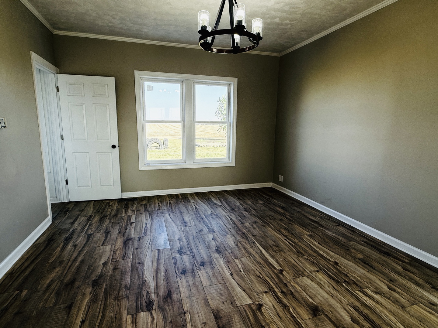 10640 South Johnny Run Road Kinsman, IL 60437 - Photo 7 of 19 a view of an empty room with wooden floor and a window