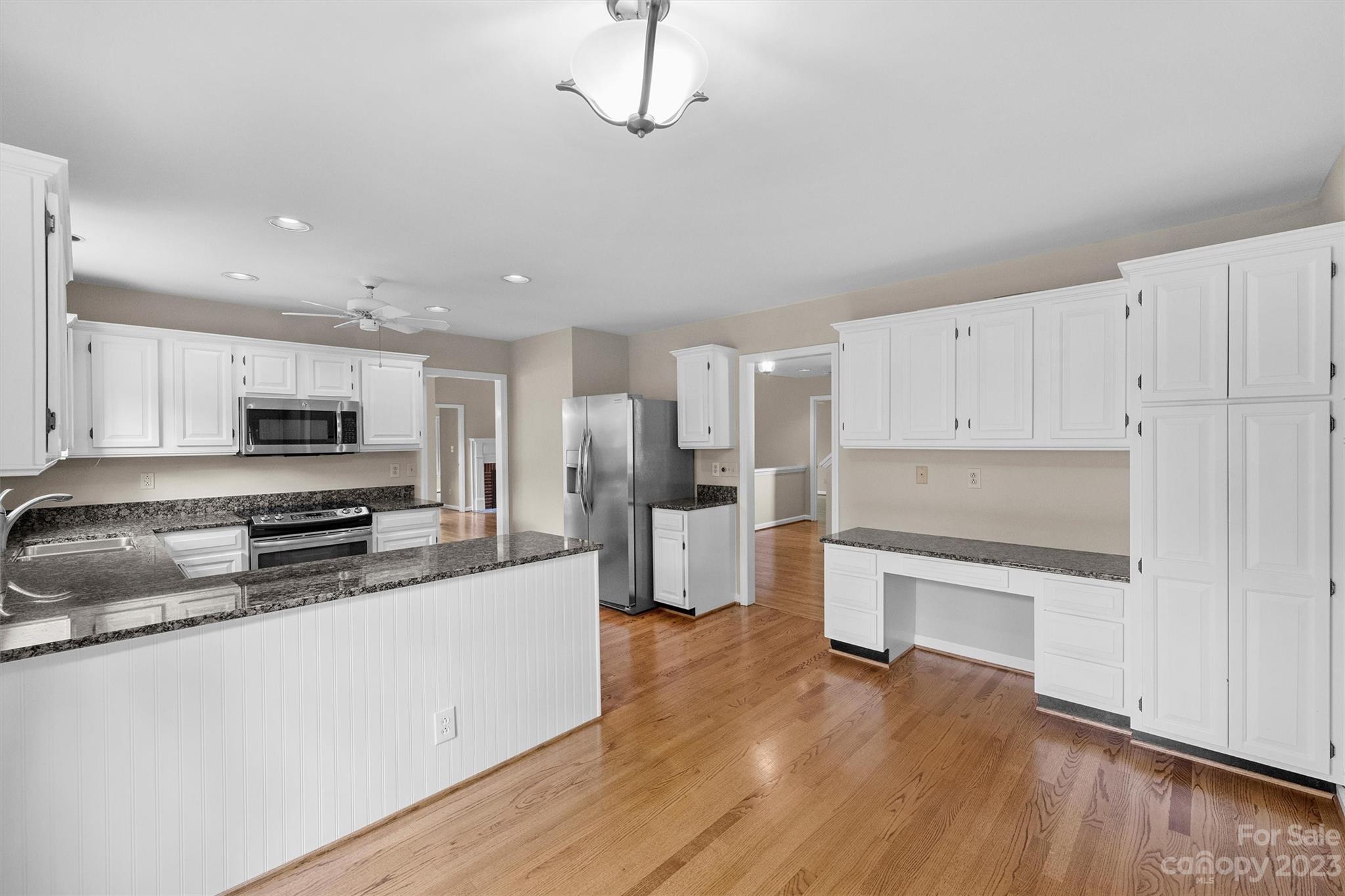 4724 Carson's Pond Road, Unit 104 Charlotte, NC 28226 - Photo 15 of 38 a large kitchen with stainless steel appliances granite countertop a stove top oven a refrigerator a sink and dishwasher with wooden floor