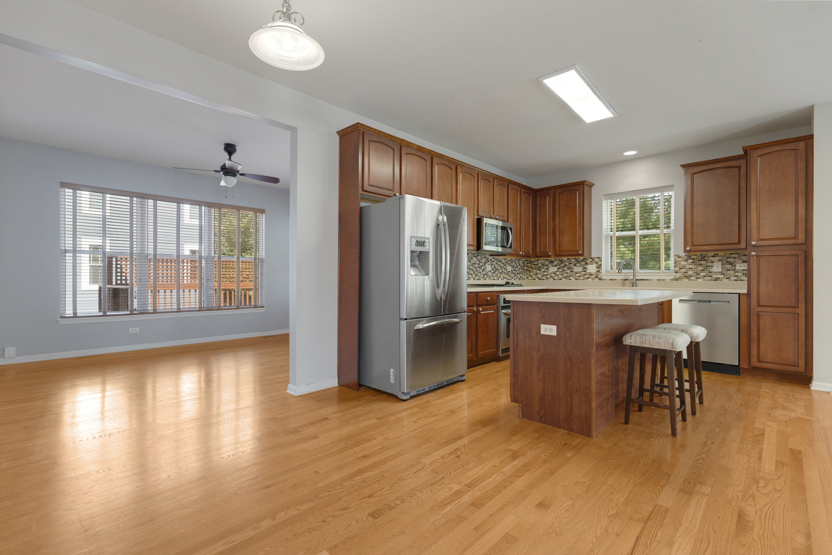 748 Hamilton Way Batavia, IL 60510 - Photo 9 of 36 a kitchen with kitchen island granite countertop wooden floors and stainless steel appliances