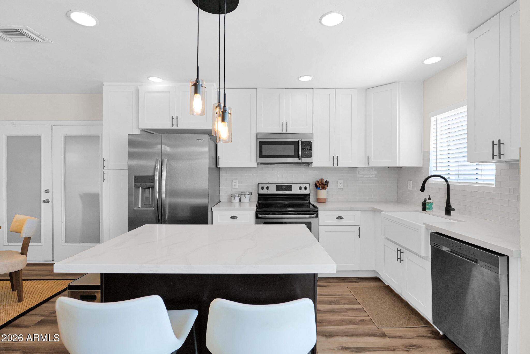 1908 East Pinchot Avenue, Unit 1908 EA Phoenix, AZ 85016 - Photo 6 of 36 a kitchen with stainless steel appliances a sink a stove a refrigerator cabinets and chairs