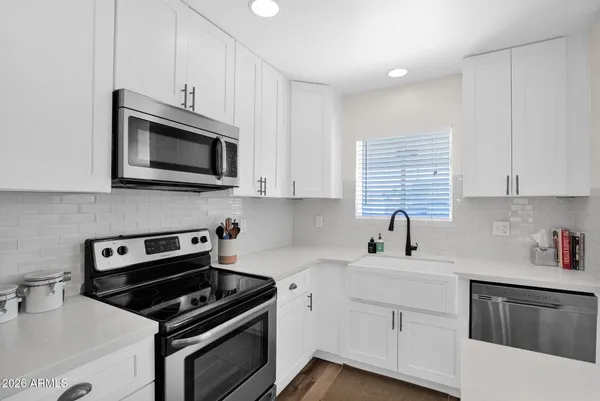 a kitchen with cabinets stainless steel appliances a sink and a counter space