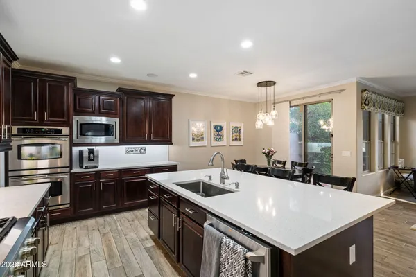 a kitchen with stainless steel appliances a sink a stove top oven a counter space and cabinets