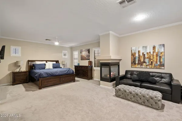 a spacious bedroom with a bed a couch and dresser