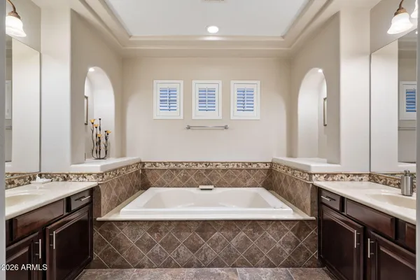a spacious bathroom with a tub sink and mirror