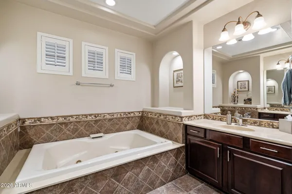 a bathroom with a tub a sink and mirror