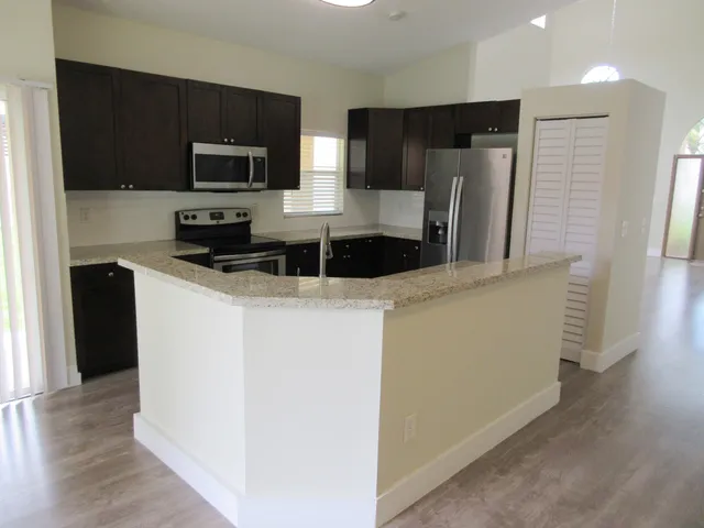 a kitchen with stainless steel appliances a refrigerator a stove a microwave a sink and a refrigerator