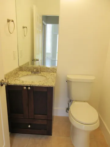 a bathroom with a granite countertop toilet and a sink