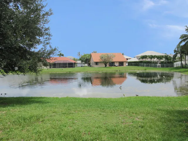 a view of a lake with a big yard and a large trees