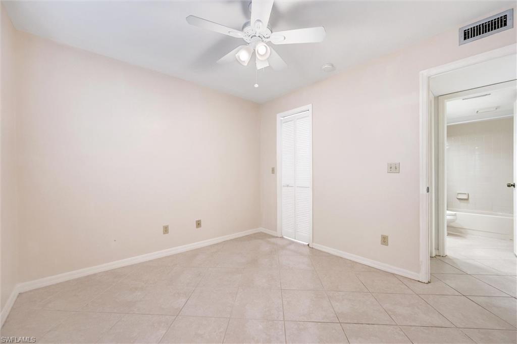 5825 Rattlesnake Hammock Road, Unit 107 Naples, FL 34113 - Photo 23 of 38 Unfurnished bedroom featuring light tile patterned floors, a ceiling fan, and a closet