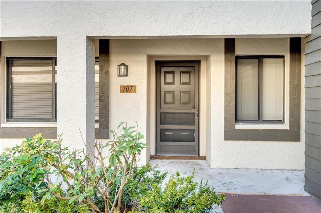 5825 Rattlesnake Hammock Road, Unit 107 Naples, FL 34113 - Photo 3 of 38 front view of a house with a door and chair
