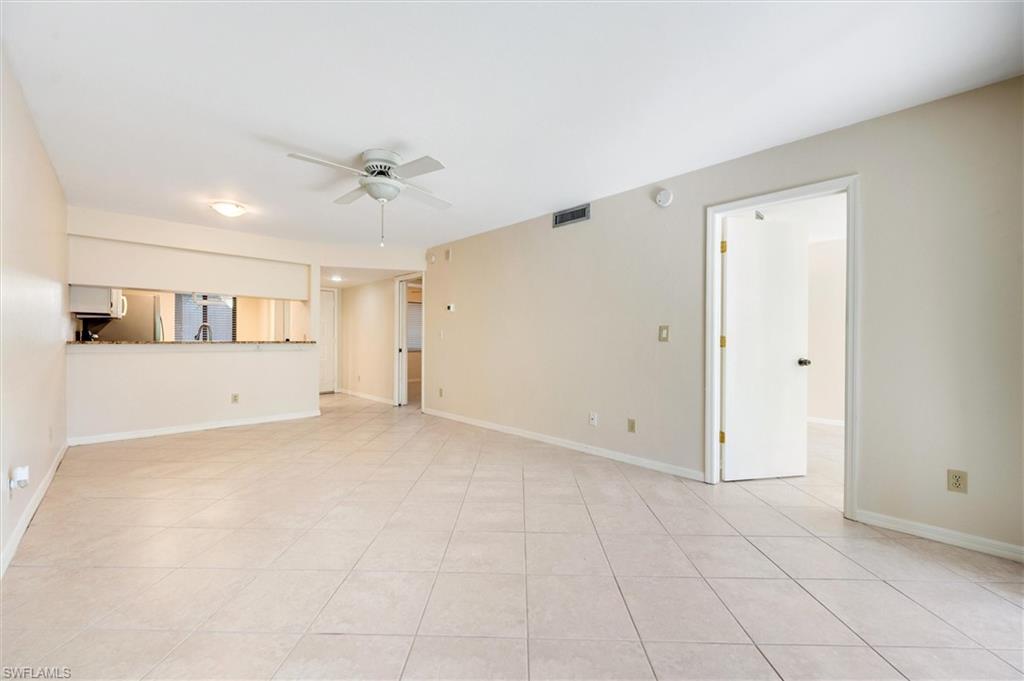 5825 Rattlesnake Hammock Road, Unit 107 Naples, FL 34113 - Photo 9 of 38 Unfurnished living room featuring a ceiling fan and light tile patterned floors