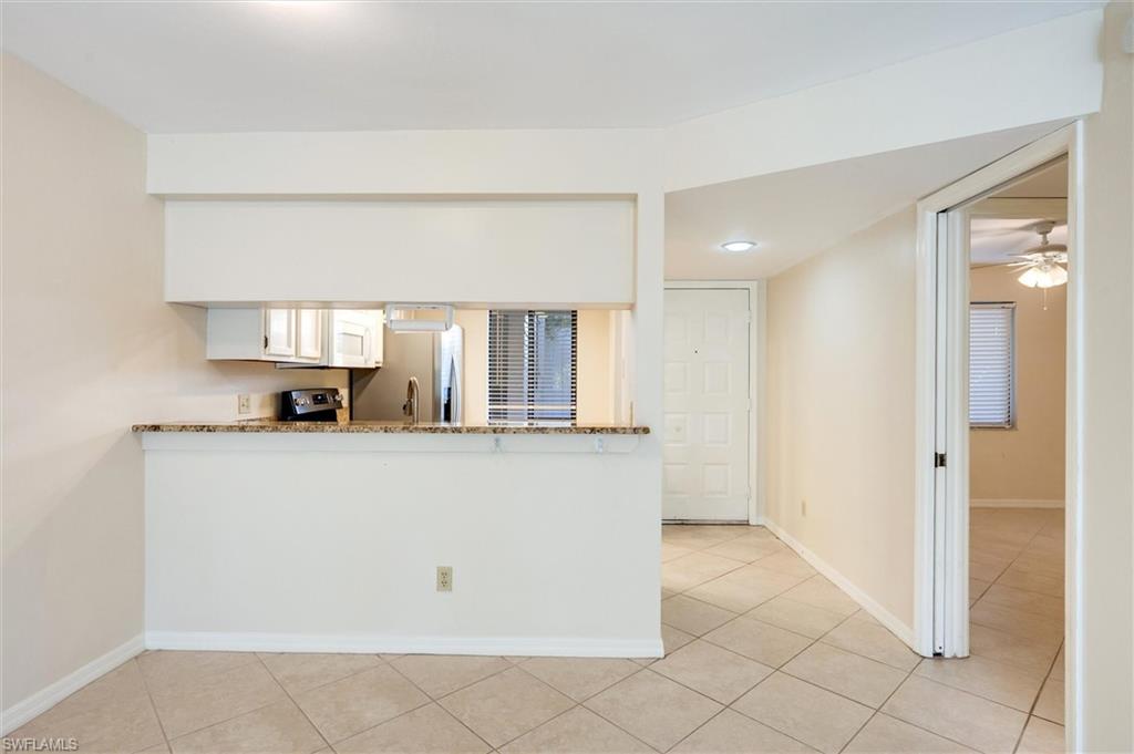 5825 Rattlesnake Hammock Road, Unit 107 Naples, FL 34113 - Photo 10 of 38 a living room with stainless steel appliances a refrigerator and a cabinets