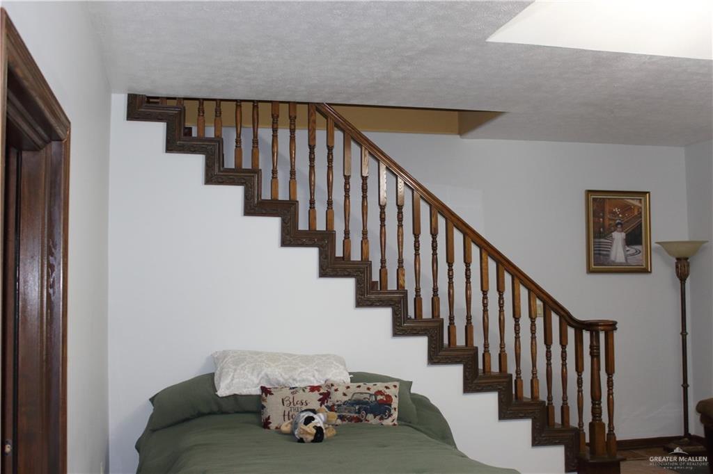322 North Charco Blanco Road Rio Grande City, TX 78582 - Photo 20 of 28 a view of staircase with lots of frames on wall and wooden floor