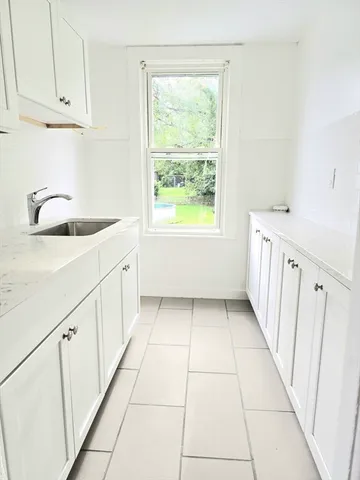 a kitchen with granite countertop white cabinets and white appliances