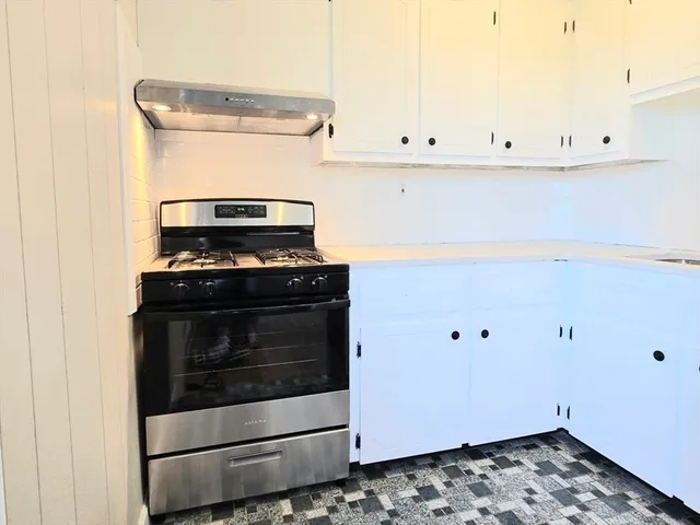 a stove top oven sitting inside of a kitchen