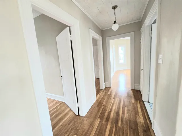 a view of a hallway with wooden floor and staircase