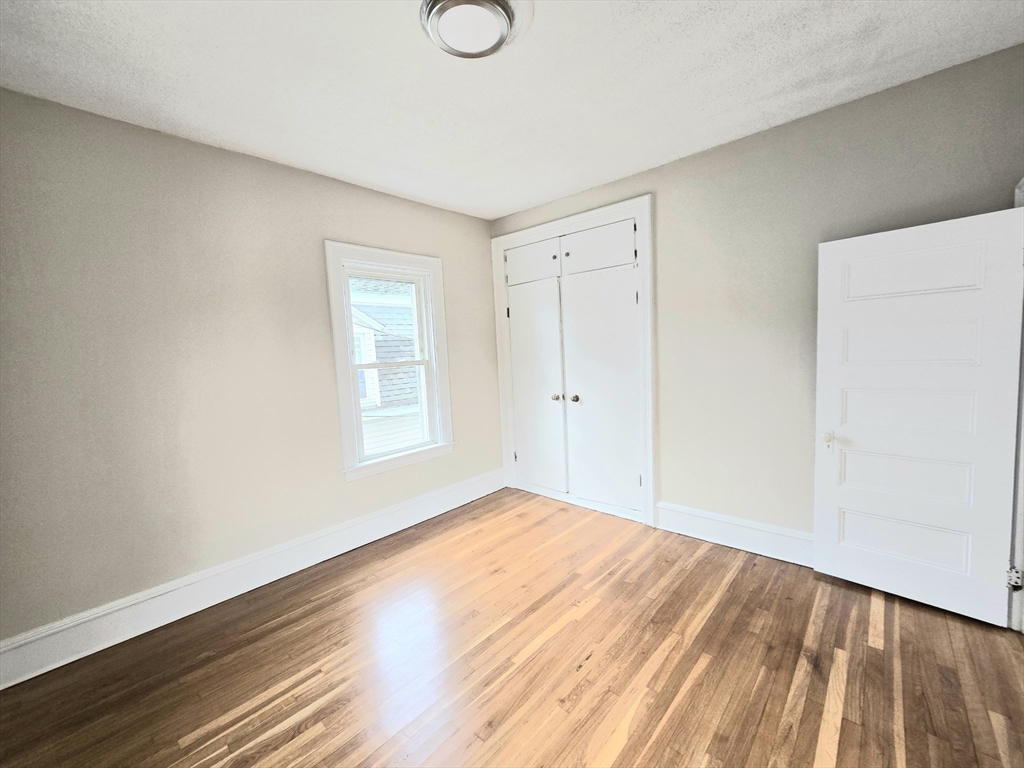 24 Ash Street, Unit 3 Fall River, MA 02724 - Photo 10 of 15 a view of an empty room with wooden floor and a window
