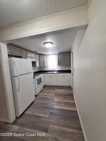 a kitchen with granite countertop a refrigerator and a sink