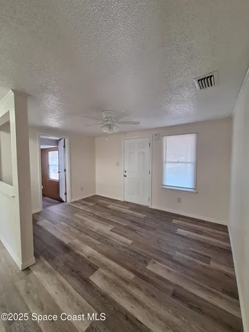 a view of empty room with wooden floor