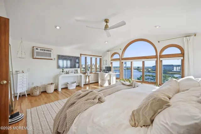 a bedroom with a bed a large window and furniture