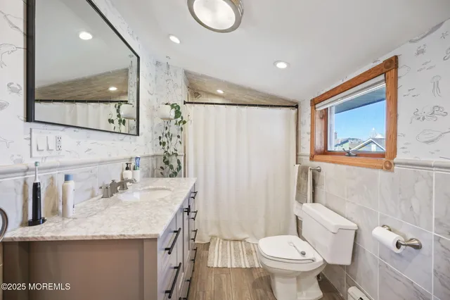 a bathroom with a granite countertop sink toilet and shower