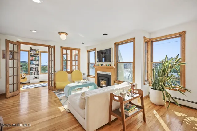 a living room with furniture large window and wooden floor