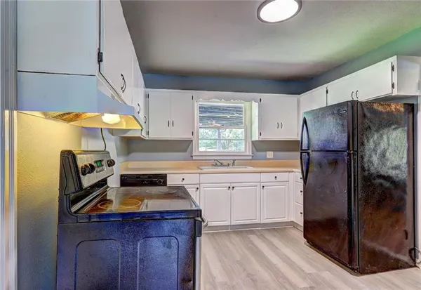a kitchen with a appliances a sink and a cabinets