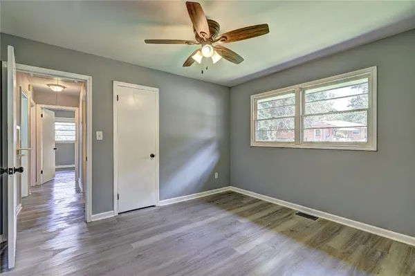 a view of an empty room with wooden floor and a window