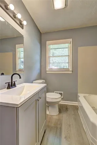 a bathroom with a toilet sink and mirror