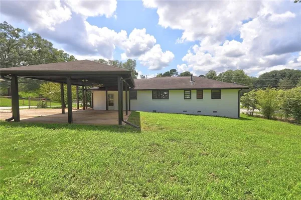 a view of a house with backyard and a tree