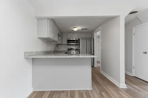 a kitchen with stainless steel appliances granite countertop a sink and a refrigerator
