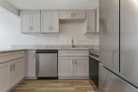 a kitchen with stainless steel appliances granite countertop a sink stove and cabinets