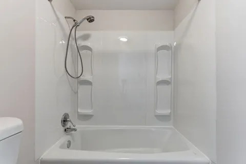 a bathroom with a bath tub with a shower