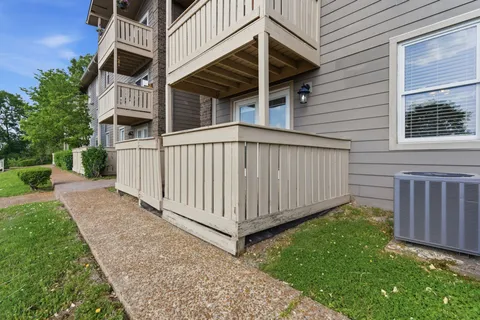 a view of a small yard in front of a house with wooden fence