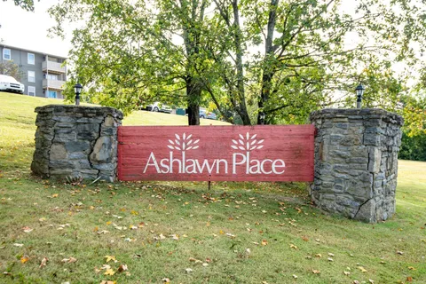 a sign that is sitting in front of a brick building