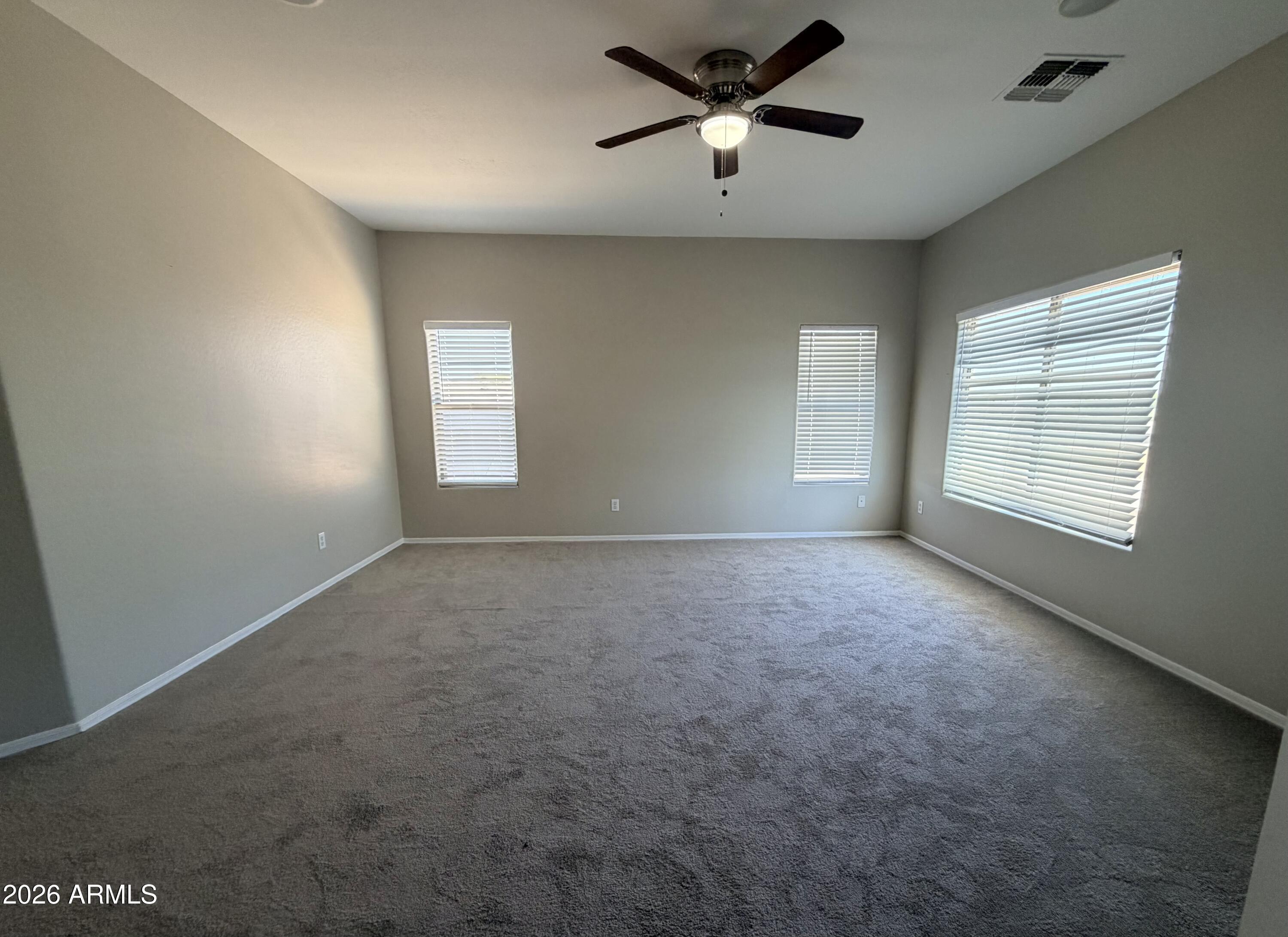 191 West Rio Drive Casa Grande, AZ 85122 - Photo 15 of 34 en empty room with windows and ceiling fan
