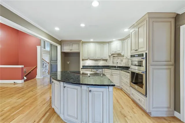 a view of a hallway with a chandelier fan and windows